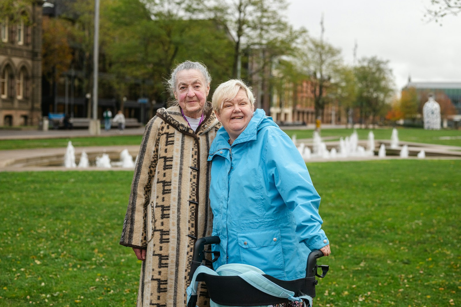 Dos amigas mayores sonríen juntas durante un paseo al aire libre en un parque.